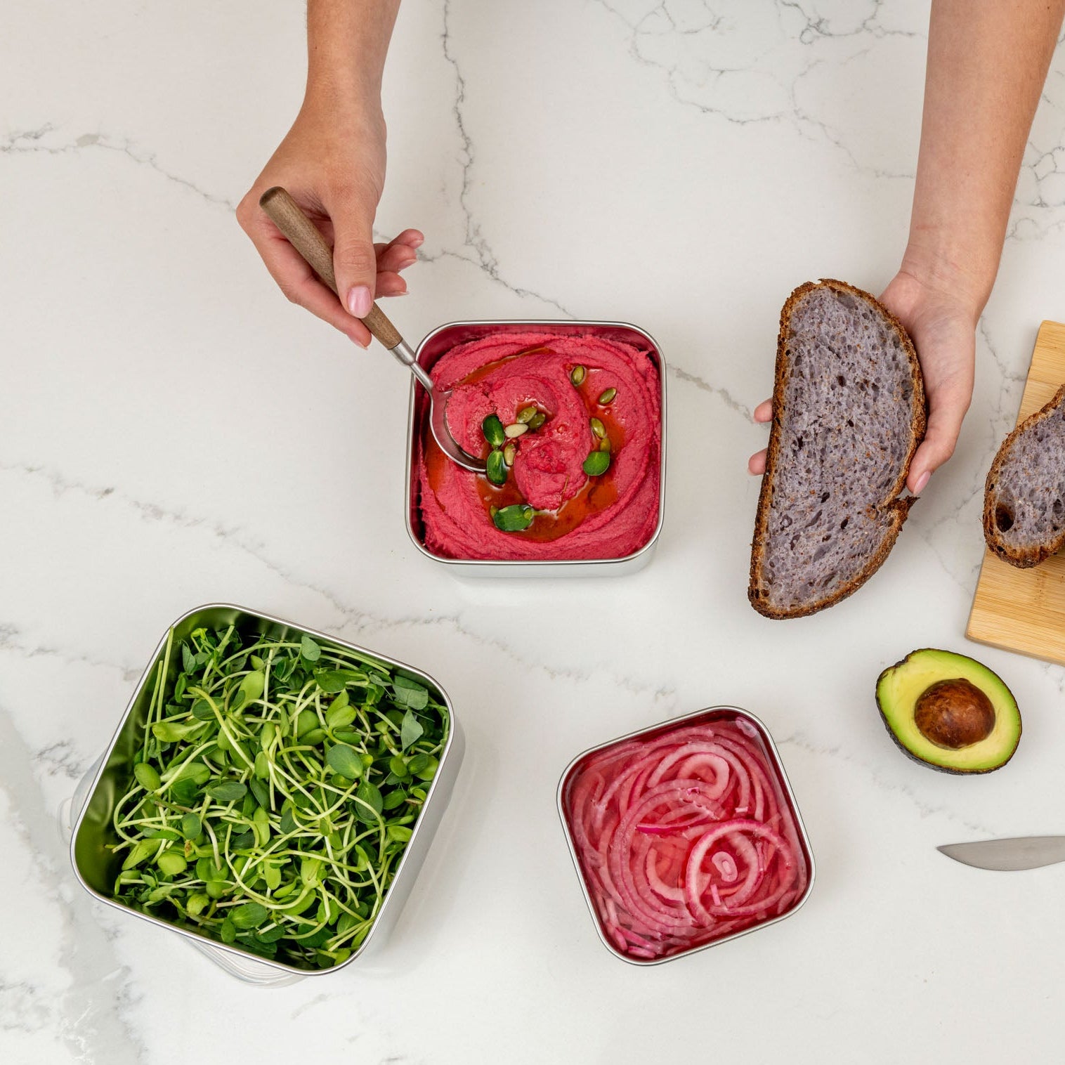 Assorted bread, vegetables, and a spread on a white marble surface